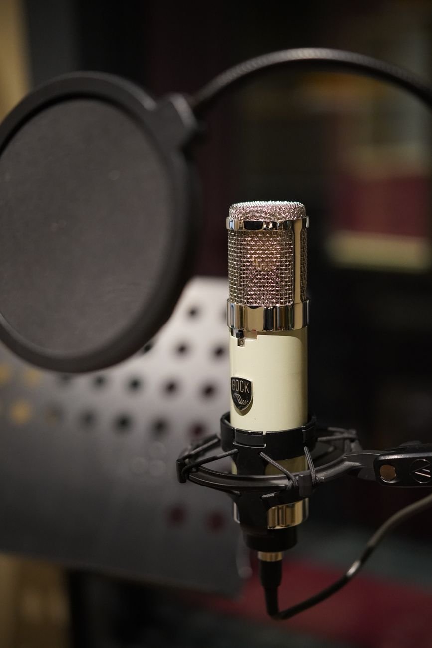 Micrófono frente a una consola de audio, imagen ilustrativa