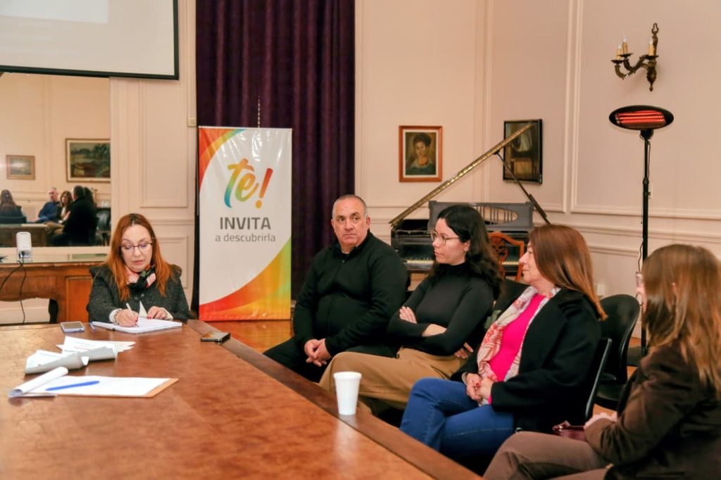 Personas participan de una reunión de la Mesa Interinstitucional contra la Trata y Explotación de Personas en Zárate. Al fondo se observa un banner de la Municipalidad.