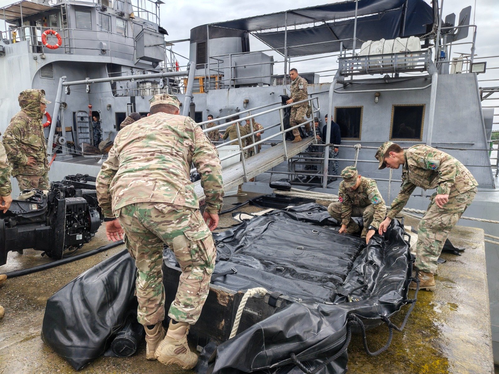 Militares preparan una embarcación neumática junto a un buque en la Base Naval Zárate.