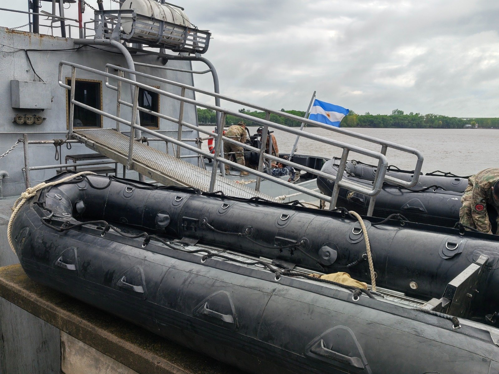 Embarcaciones neumáticas junto a un buque en el muelle de la Base Naval Zárate.