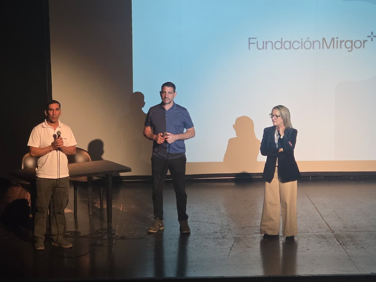 Tres representantes participan de la apertura de la capacitación de operarios industriales, delante de una pantalla con el nombre de Fundación Mirgor.
